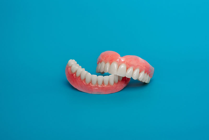 full set dentures, the top set on the bottom set with a blue background